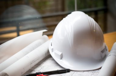 construction concept image helmet rolled blueprints on wooden bo construction concept image helmet rolled blueprints on wooden boards in retro style.